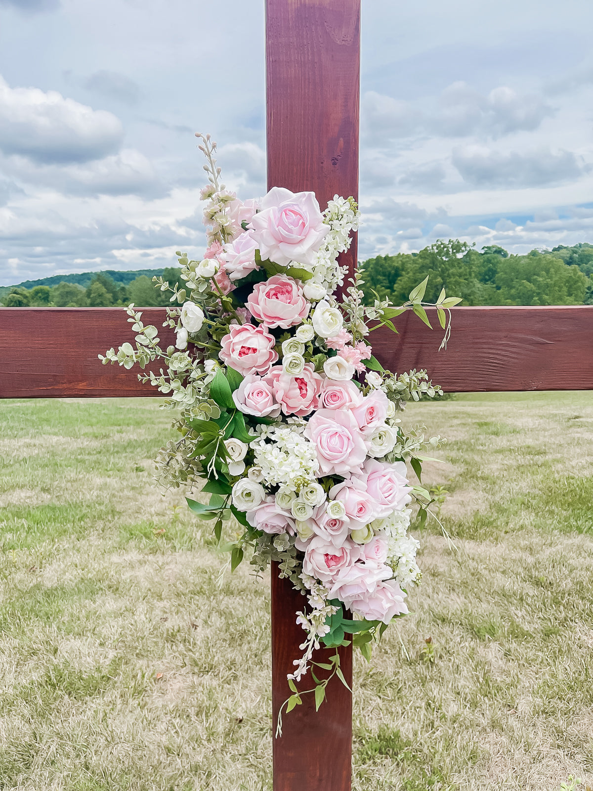 Large Wooden Cross Embellished with a Floral Garland.